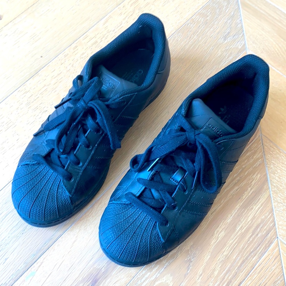 All black Adidas Superstar sneakers